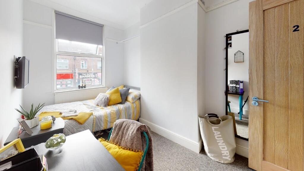 A cozy and bright single bedroom featuring a co...