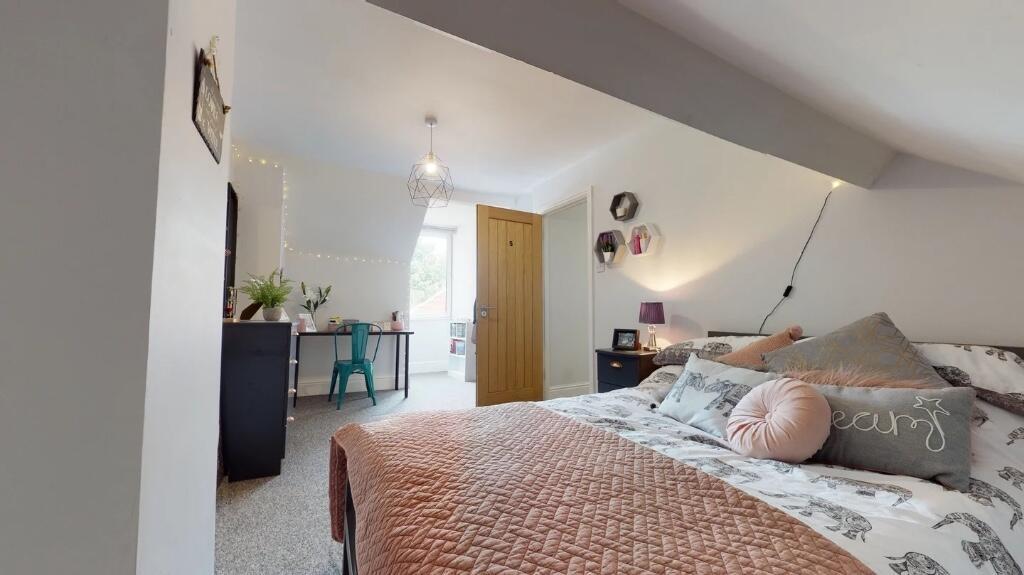 A cozy and well-lit master bedroom featuring a ...