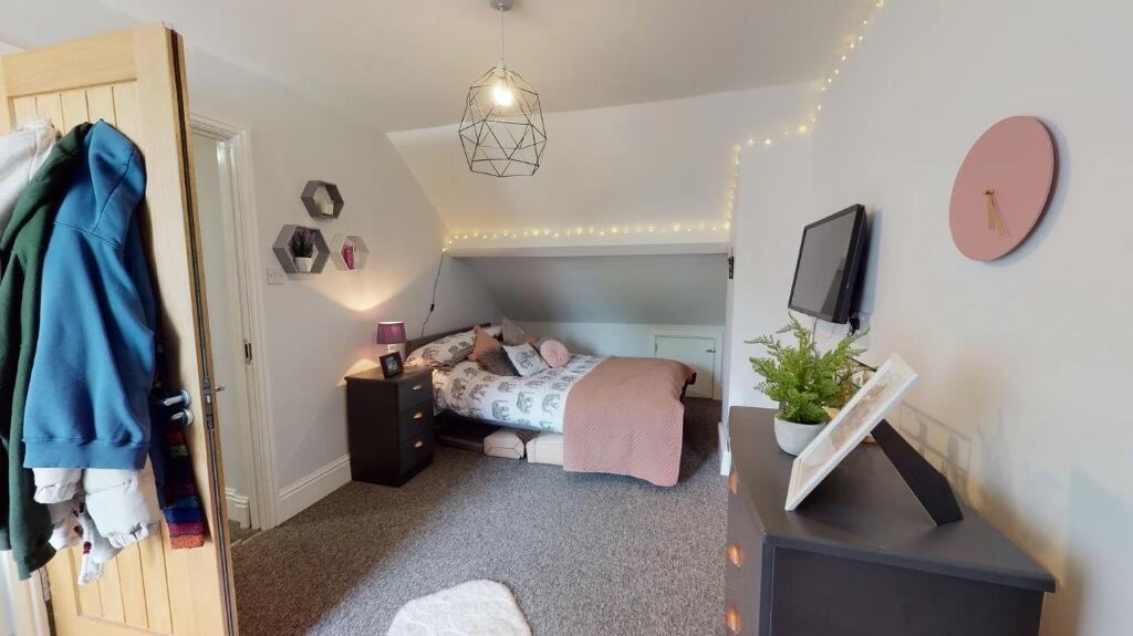 A cozy and well-decorated master bedroom featur...