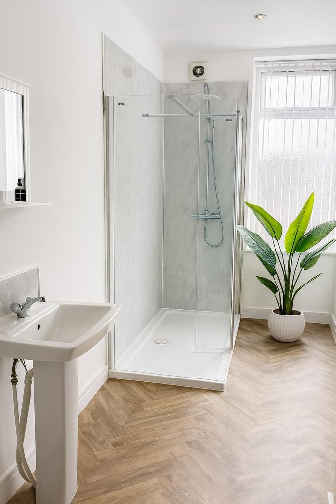 Bright, modern bathroom with a walk-in glass sh...