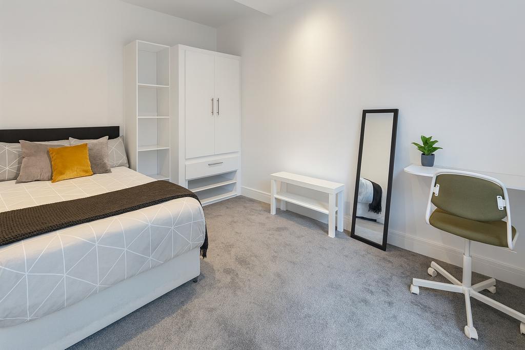 Bright, neatly furnished double bedroom with a ...