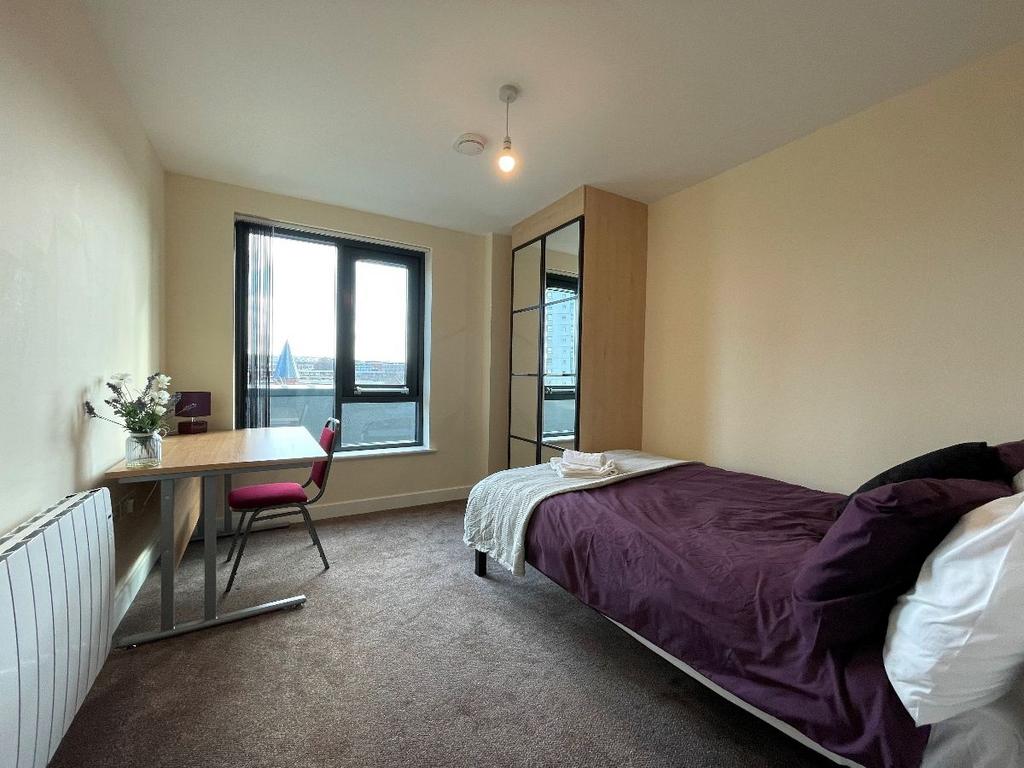 A cozy single bedroom featuring a comfortable b...