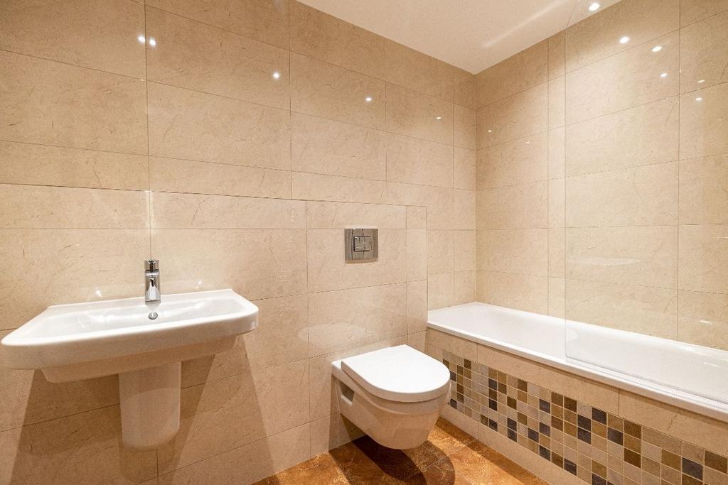 Bright and modern bathroom suite featuring a cl...