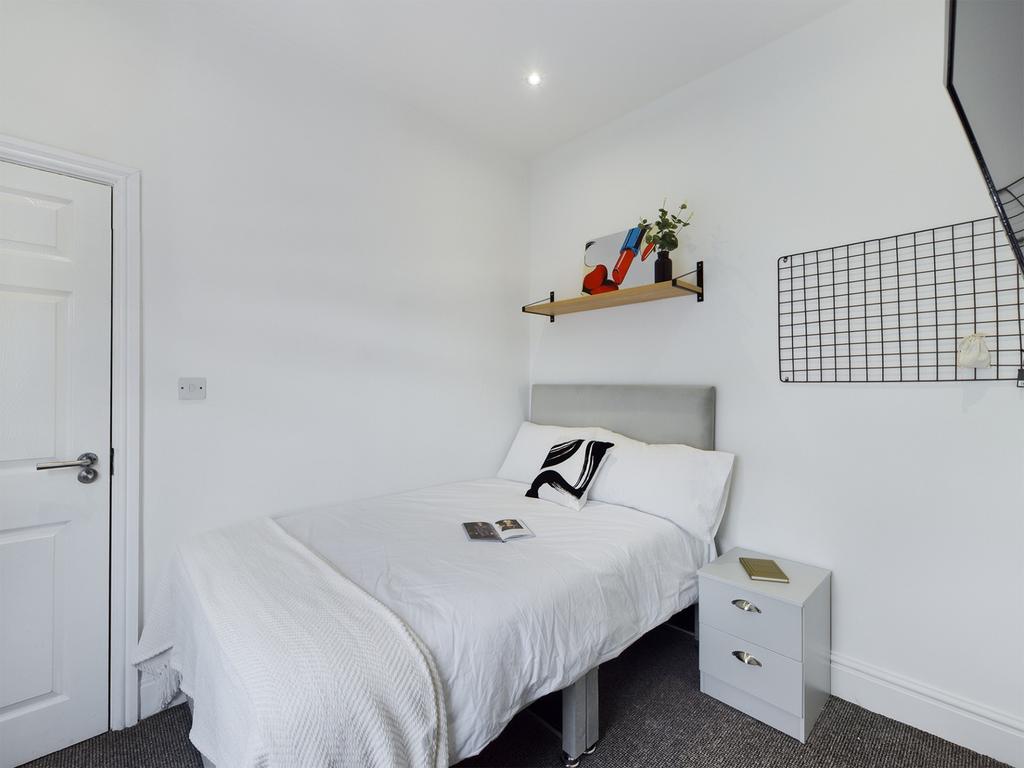 A bright and tidy double bedroom featuring mode...