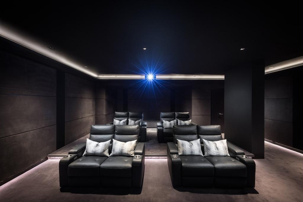 A sleek and modern private cinema room featurin...