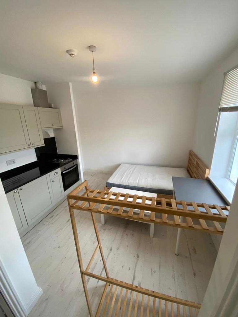 Compact and clean room featuring a small kitche...