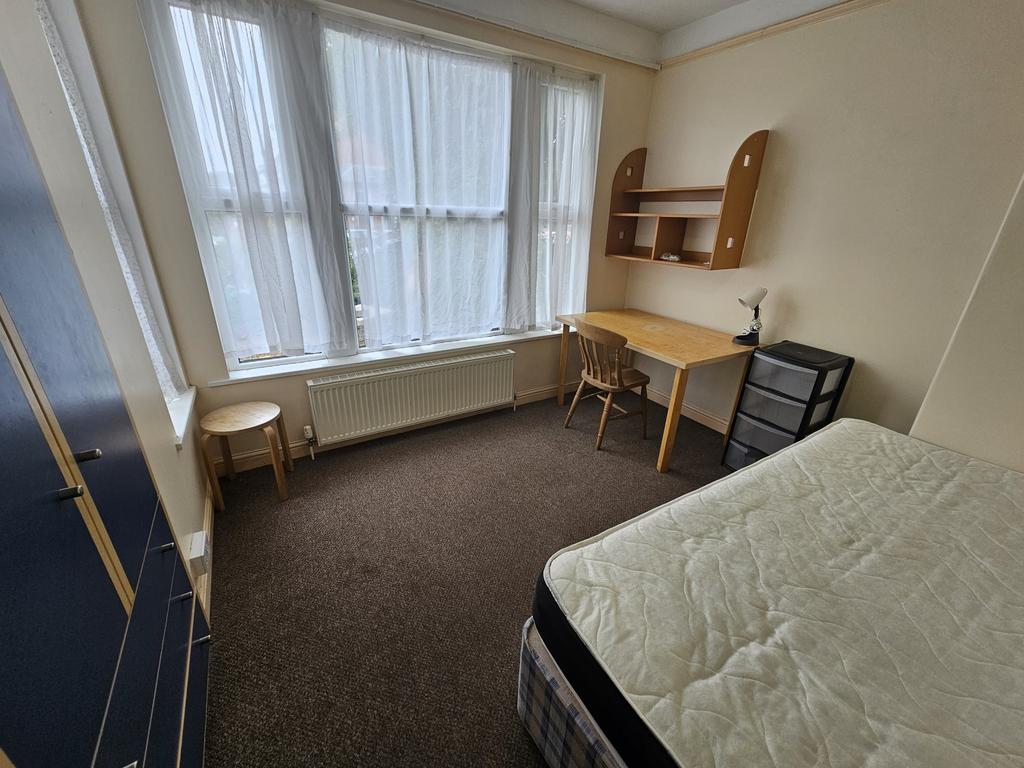 A bright and tidy single bedroom featuring a la...