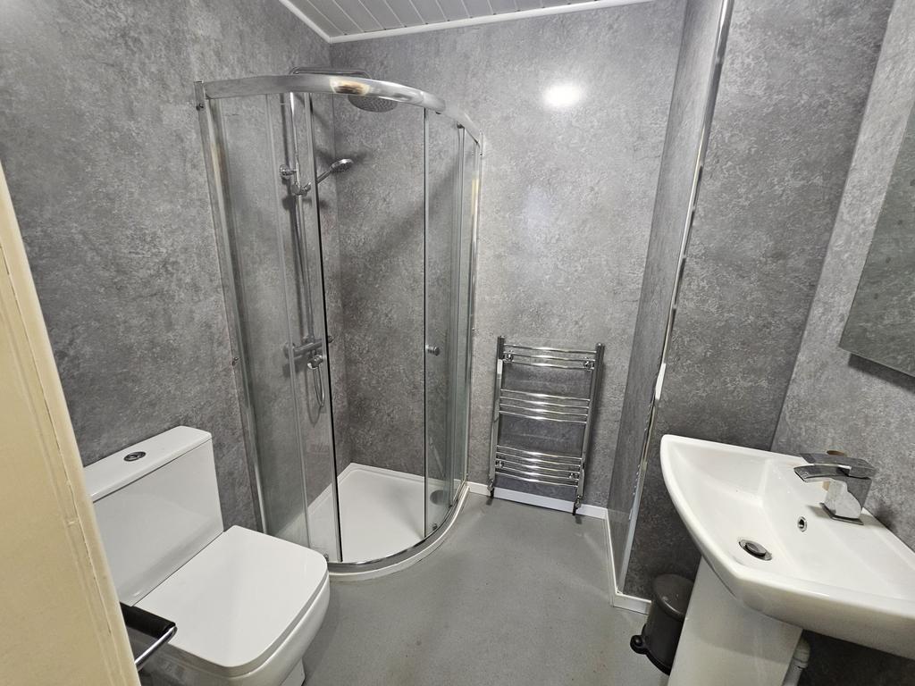 Modern bathroom featuring a spacious curved gla...