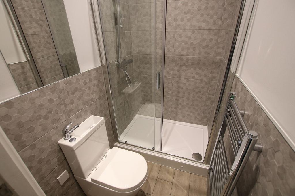 A modern bathroom featuring a clean, tiled show...