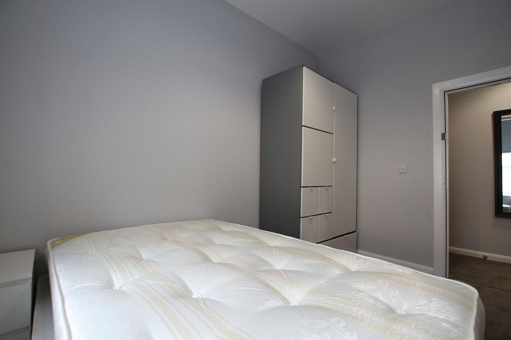 A neat and tidy single bedroom featuring a clea...