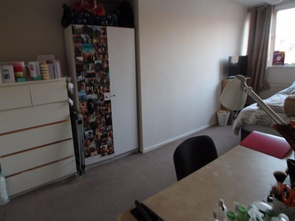 A compact and tidy room with a light beige carp...