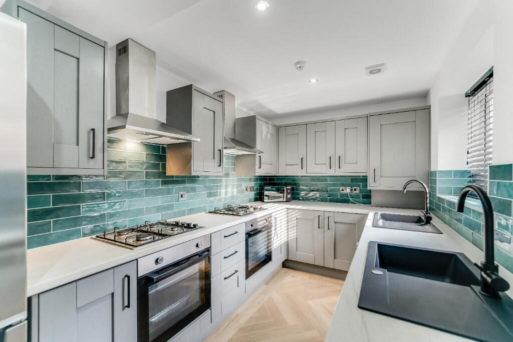 This modern kitchen features sleek cabinetry, s...