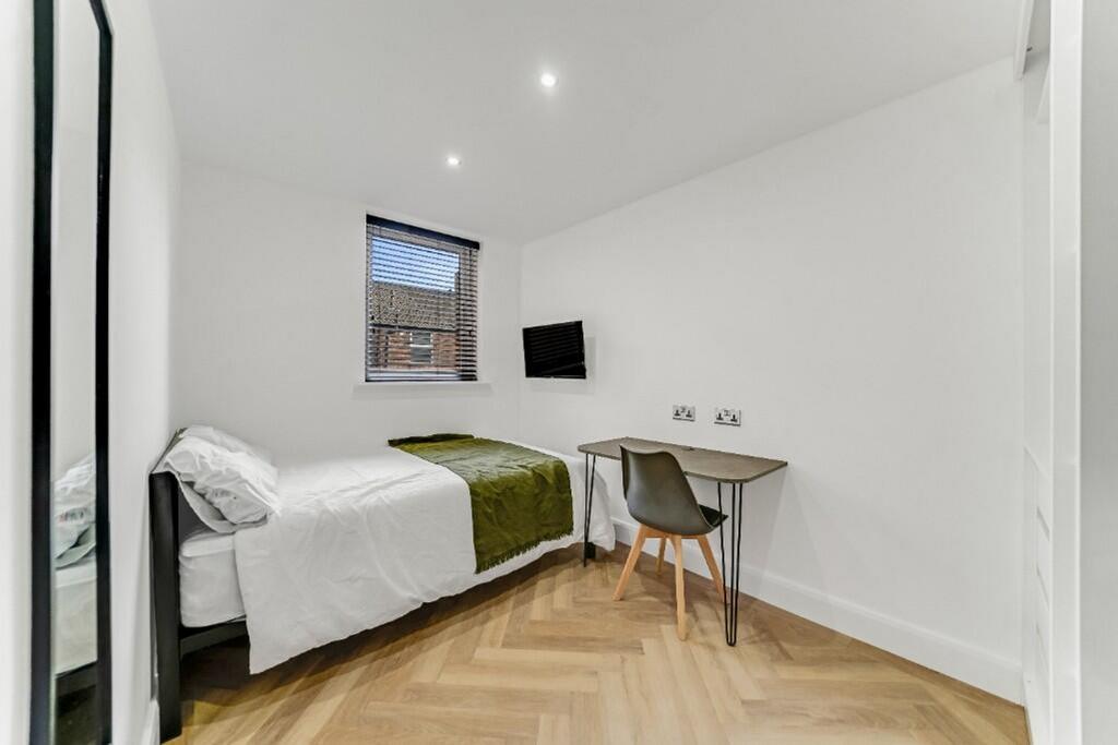 This inviting double bedroom features a cozy la...