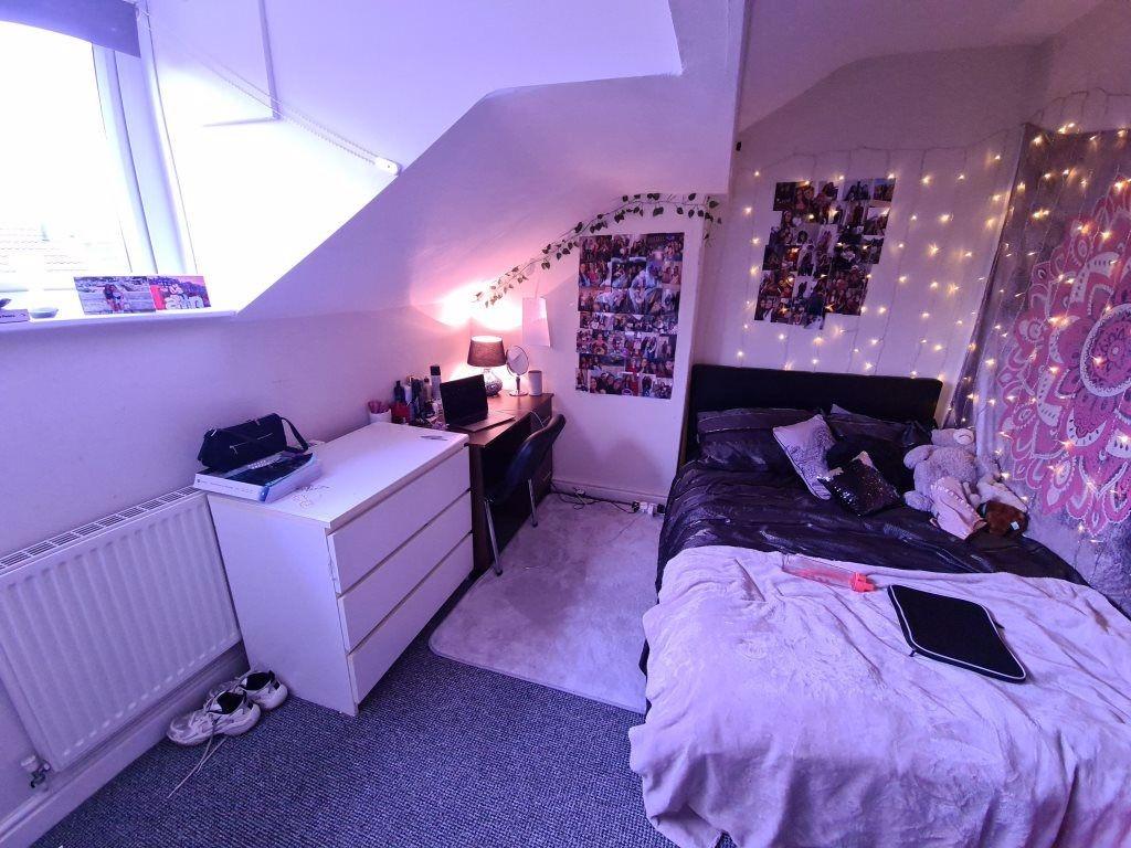 Cozy attic bedroom with a sloped ceiling and a ...