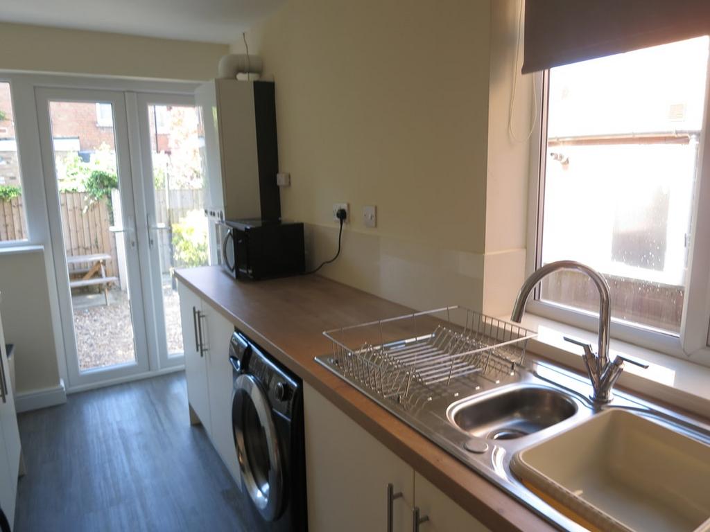 Bright galley-style kitchen with a long wooden ...