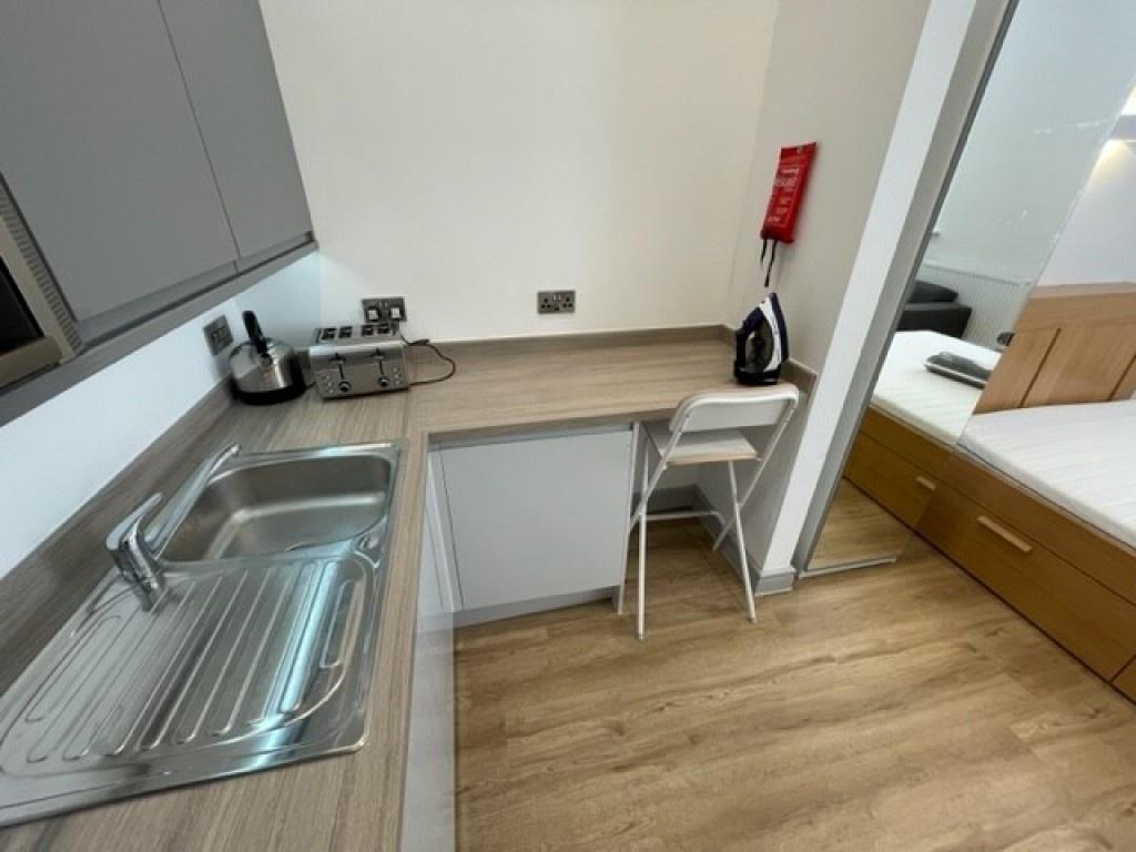A modern and tidy kitchen area featuring a stai...