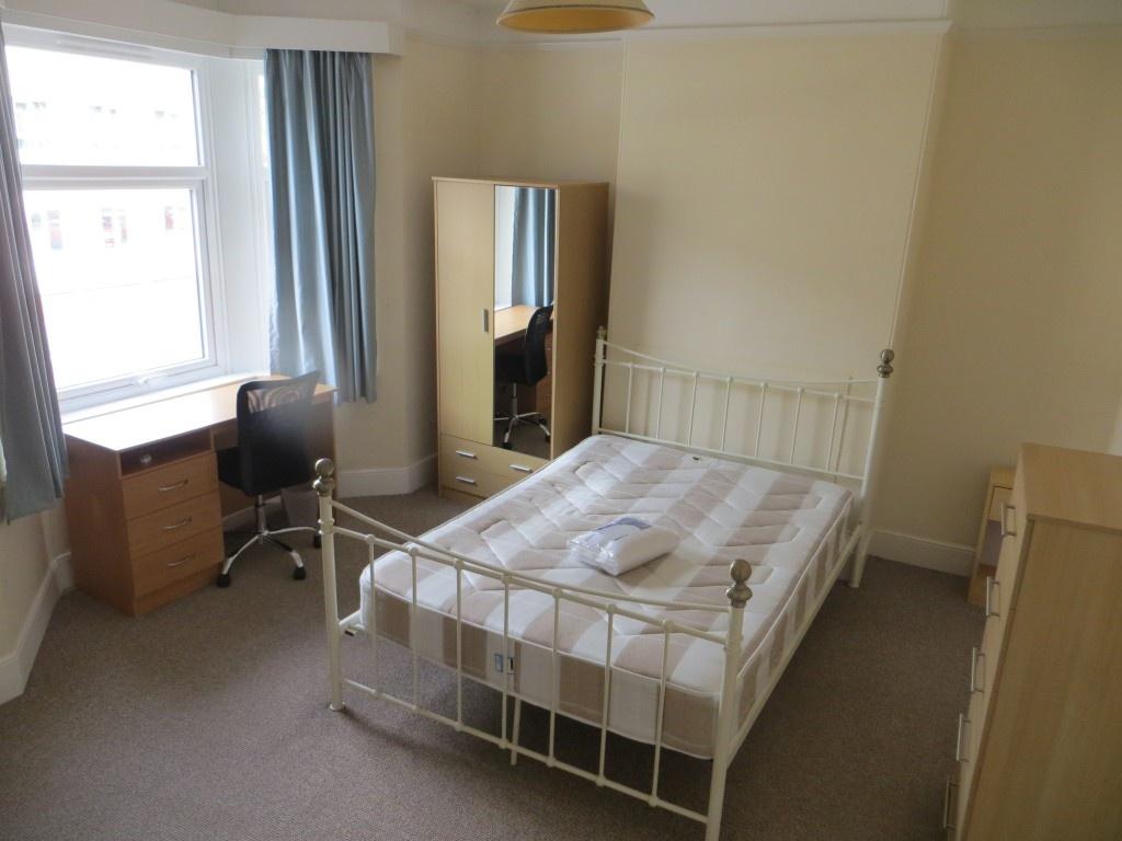Bright double bedroom featuring a large window ...