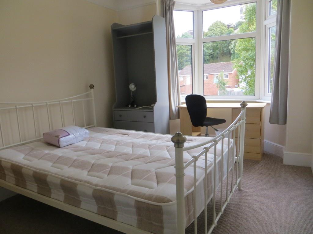 A bright double bedroom featuring a large bay w...