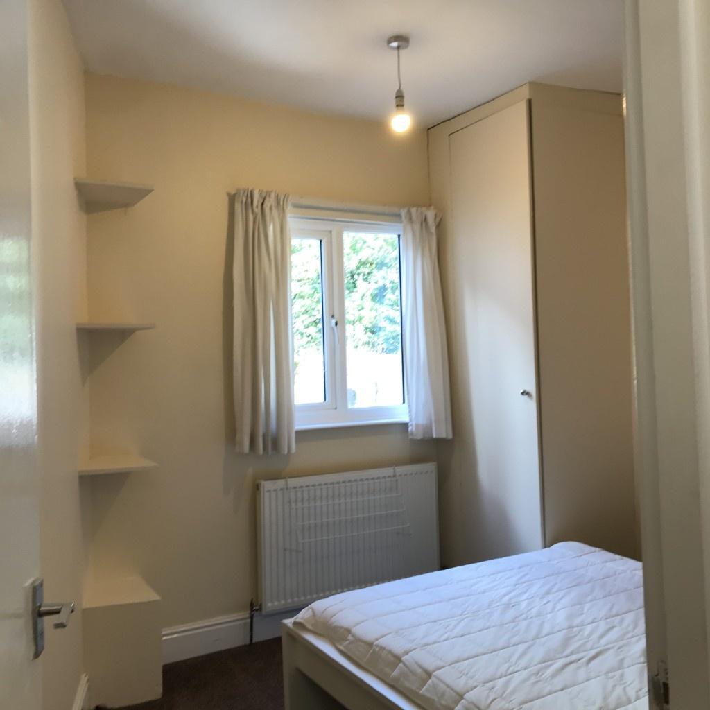 Cozy single bedroom featuring a bright window w...