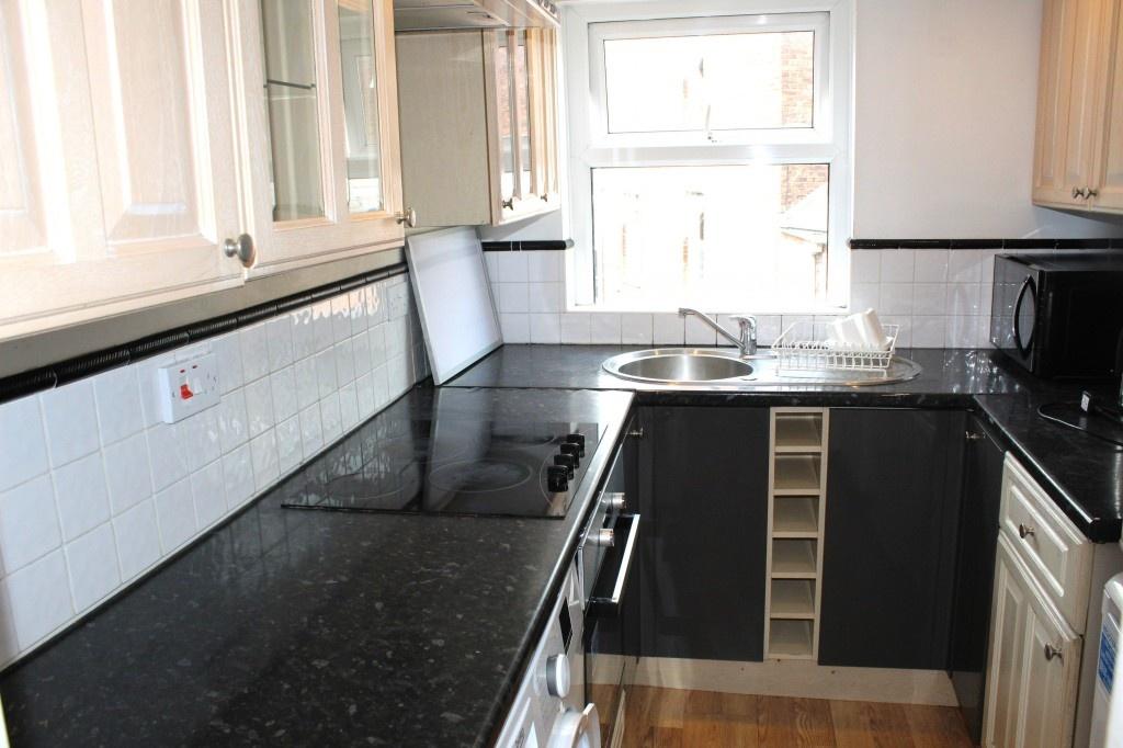 Bright and tidy kitchen featuring ample black c...