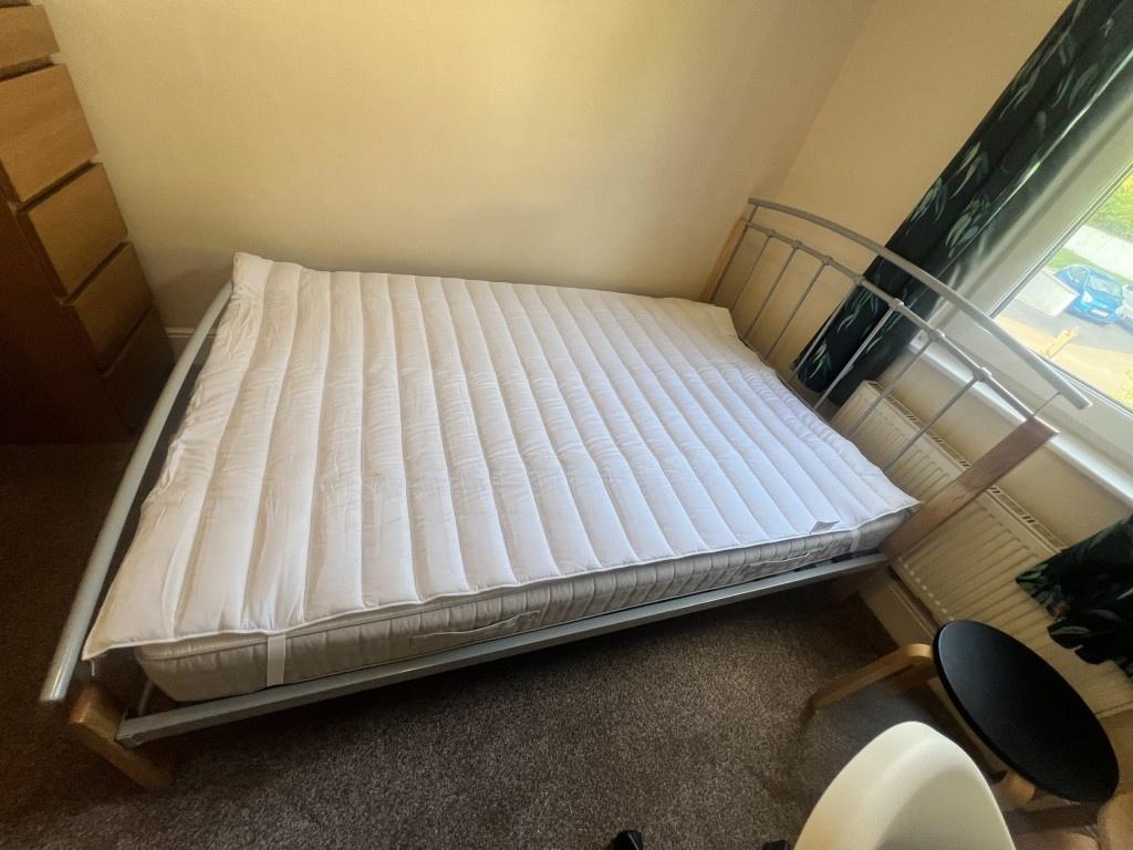 A cozy single bedroom featuring a comfortable b...