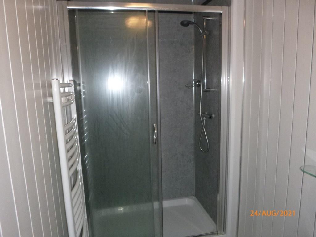 A modern bathroom featuring a clean, glass-encl...