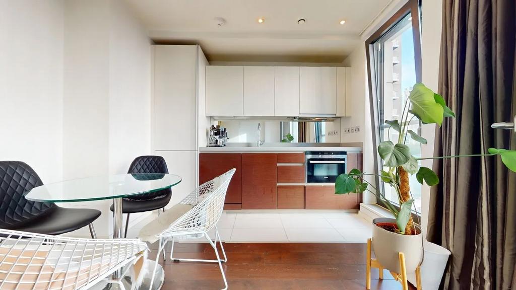 A modern kitchen area featuring sleek white and...