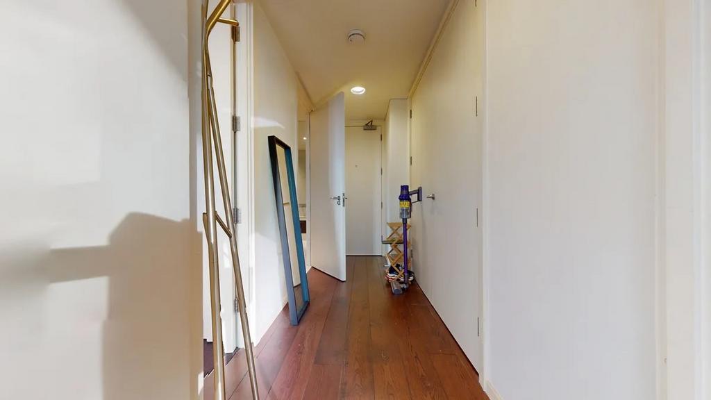 A clean, modern hallway with warm wooden floors...