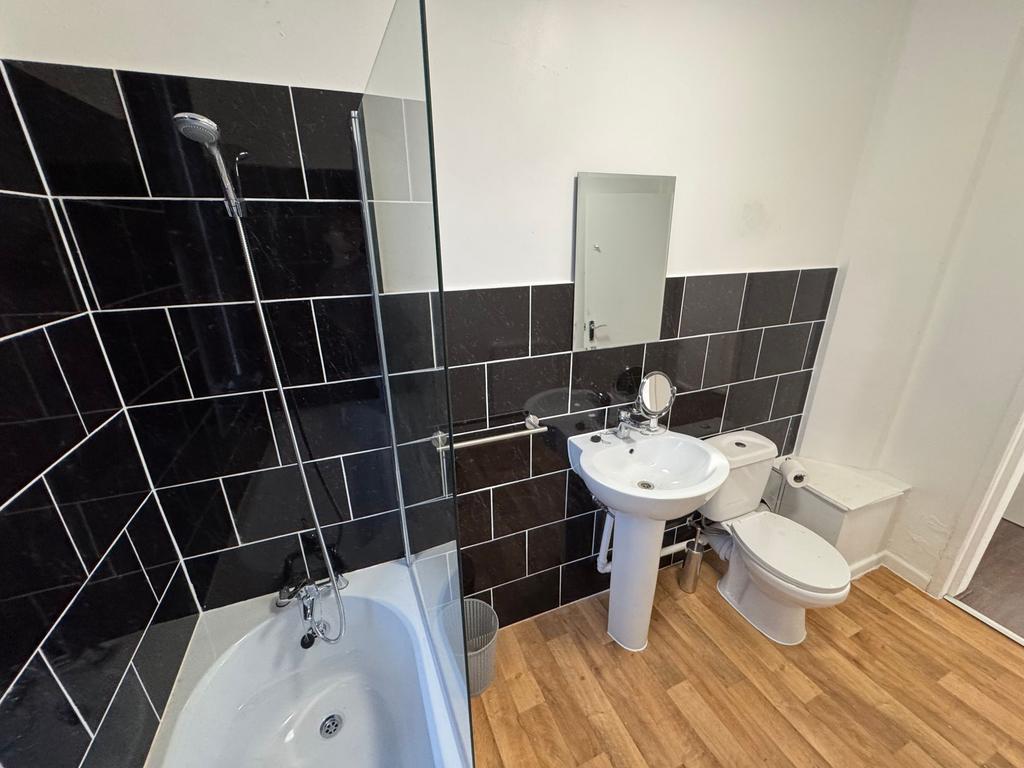 A modern bathroom suite featuring a white batht...