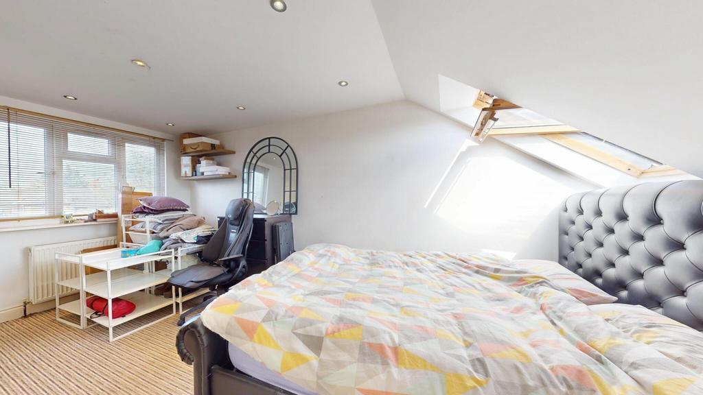 Bright and cozy attic bedroom featuring a comfo...