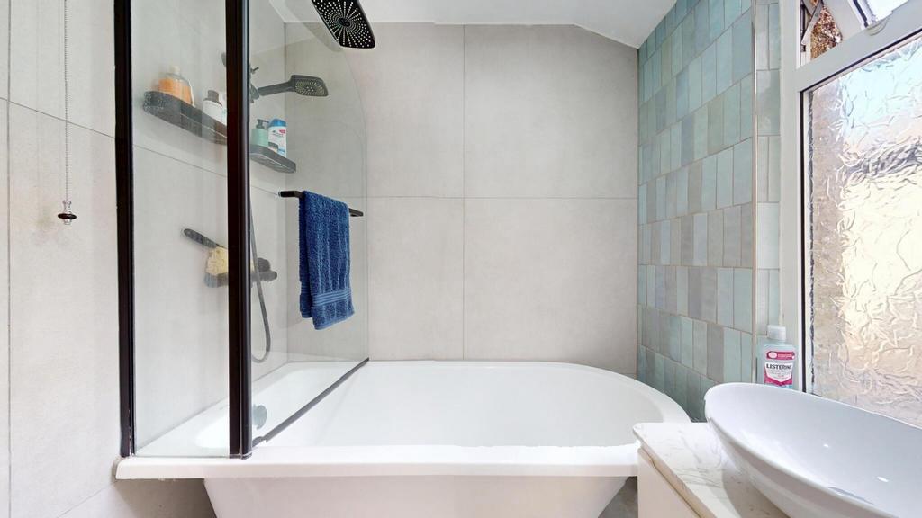 Bright bathroom suite featuring a modern bathtu...