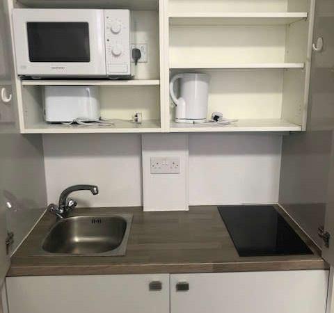 Compact and tidy kitchenette featuring essentia...