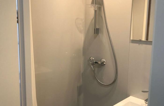 A clean, modern bathroom with a wall-mounted sh...