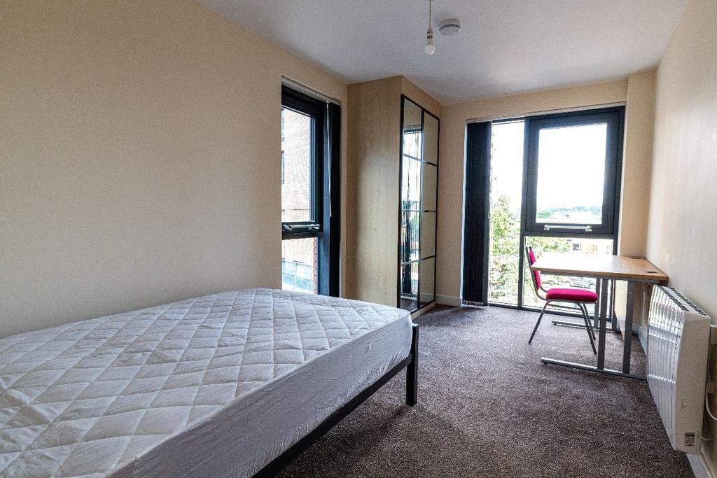 Bright single bedroom featuring large windows t...