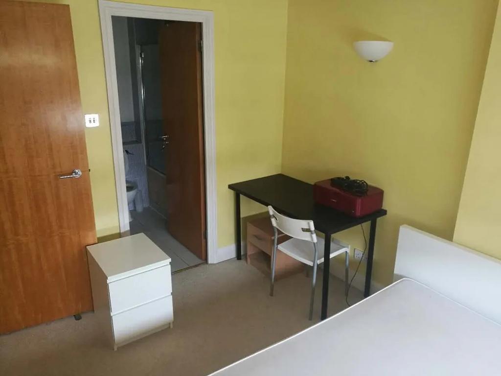 Cozy single bedroom featuring a neat study desk...