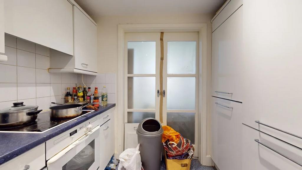 Compact kitchen space featuring white cabinetry...