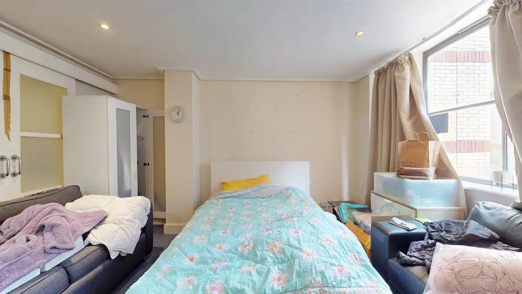 Cozy single bedroom featuring a comfortable bed...