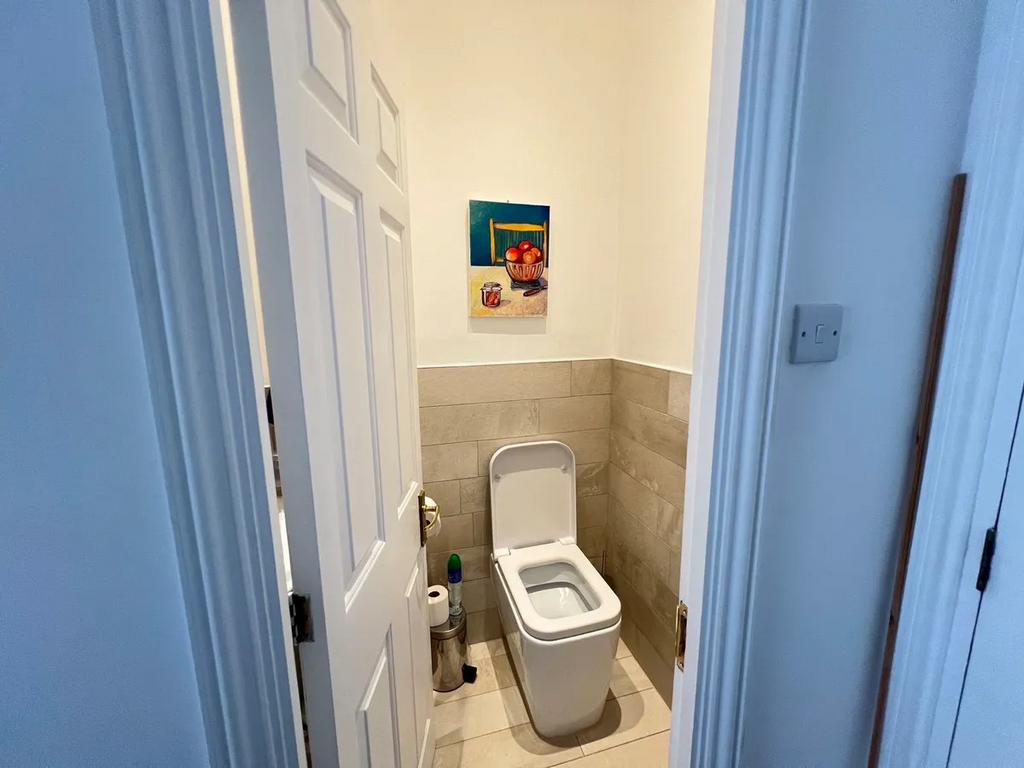 A clean and modern single toilet room featuring...