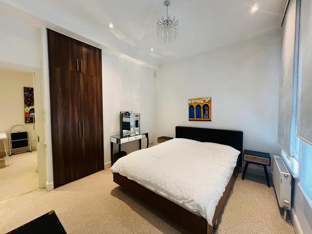 A neat and well-lit double bedroom featuring a ...