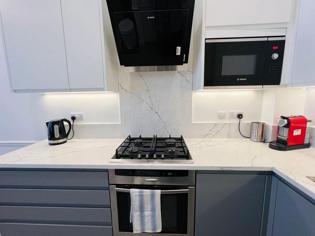 Modern kitchen featuring sleek white and gray c...