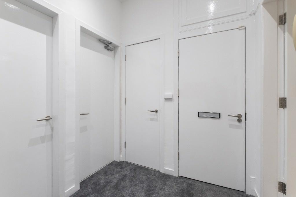 Bright and inviting hallway featuring sleek whi...