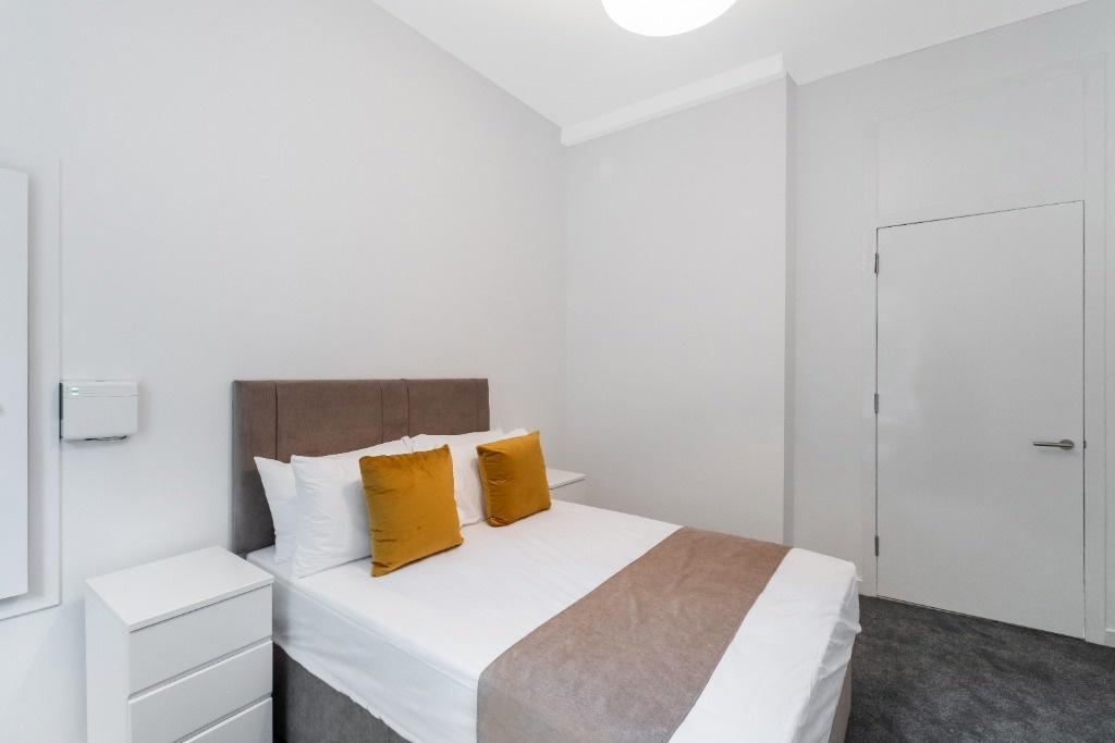 This inviting double bedroom features a comfort...
