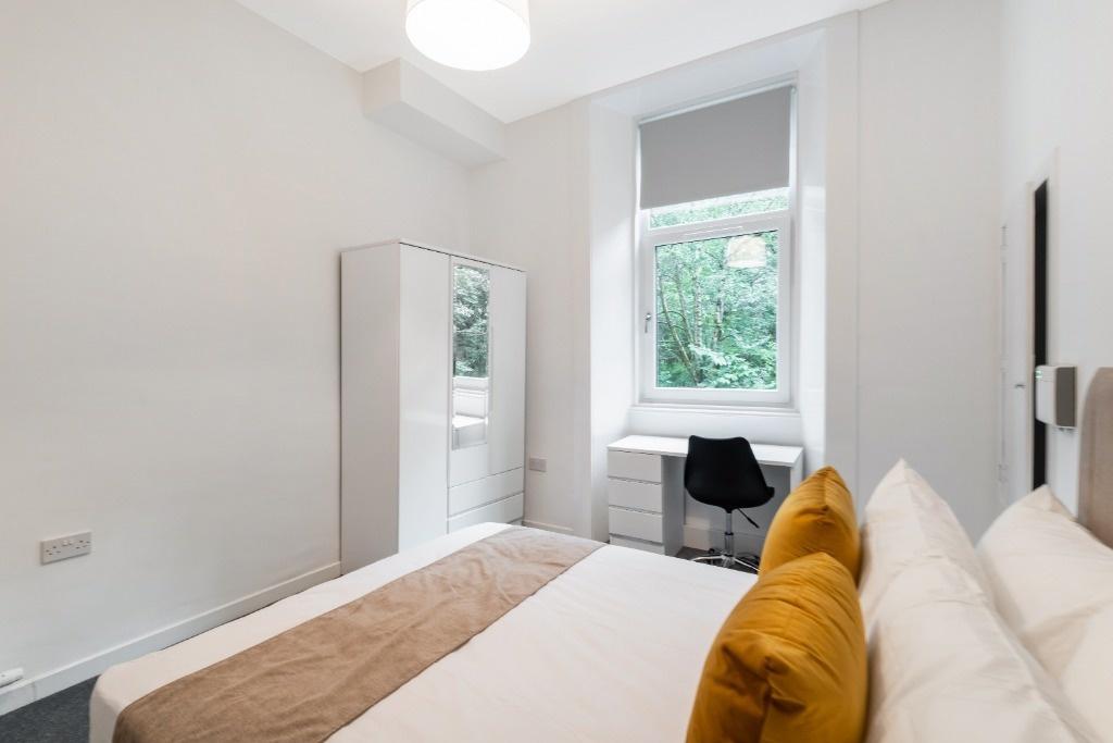 A cozy and well-lit double bedroom featuring a ...