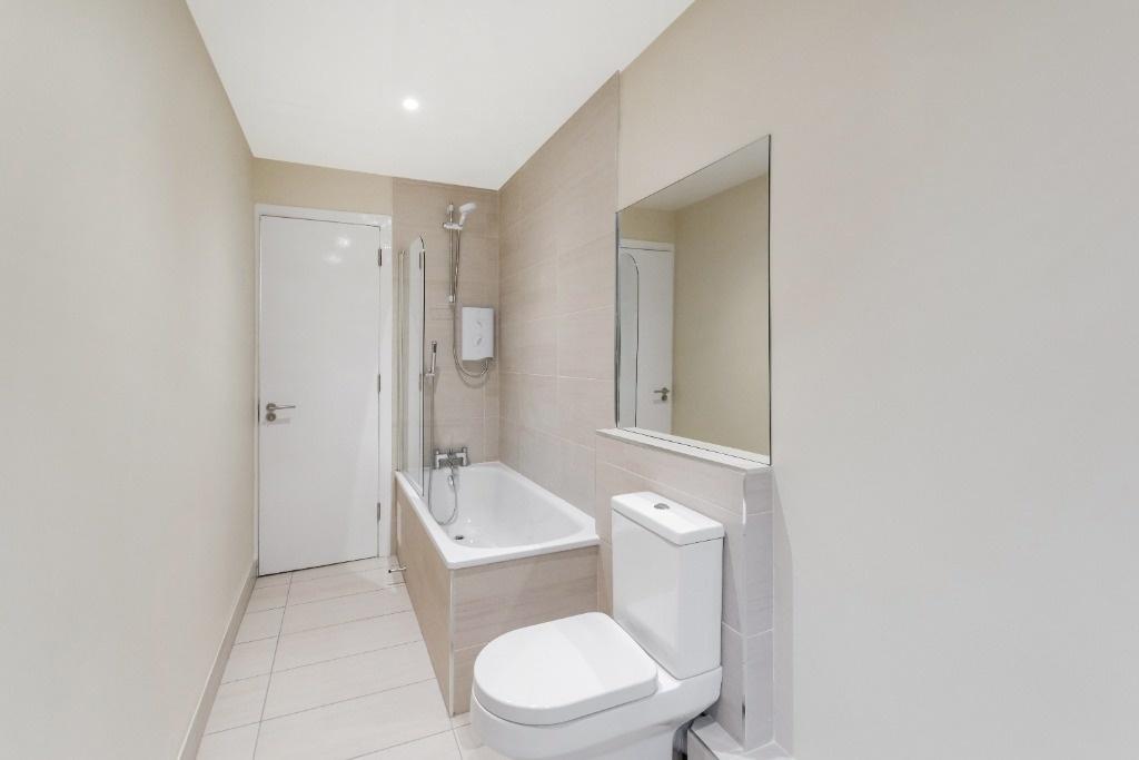 This well-maintained bathroom features a modern...