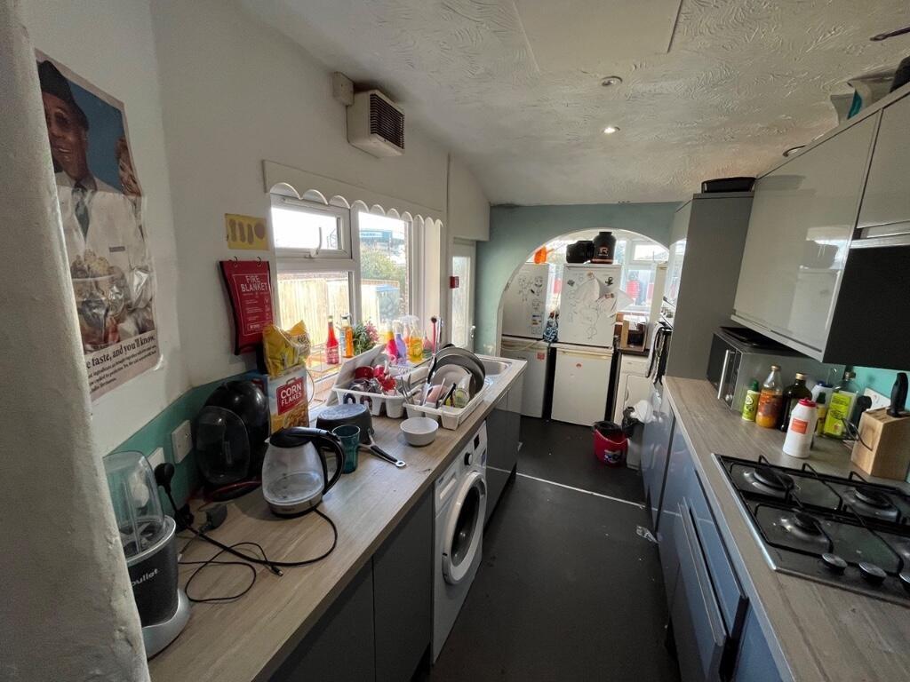 A compact kitchen space featuring modern cabine...