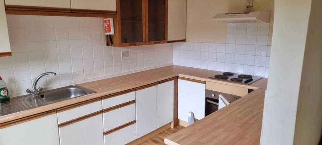 A neat kitchen featuring ample wooden counterto...