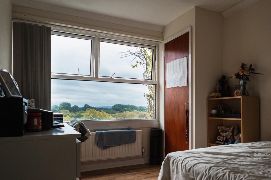 A cozy double bedroom featuring a large window ...