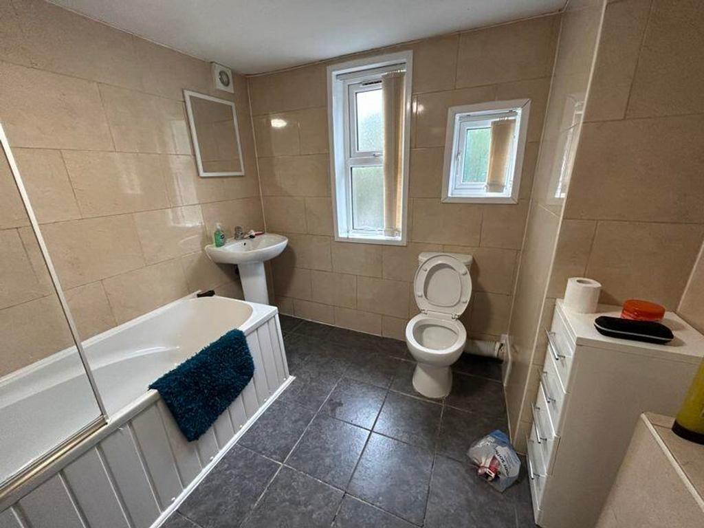 A spacious and well-lit bathroom featuring a ba...