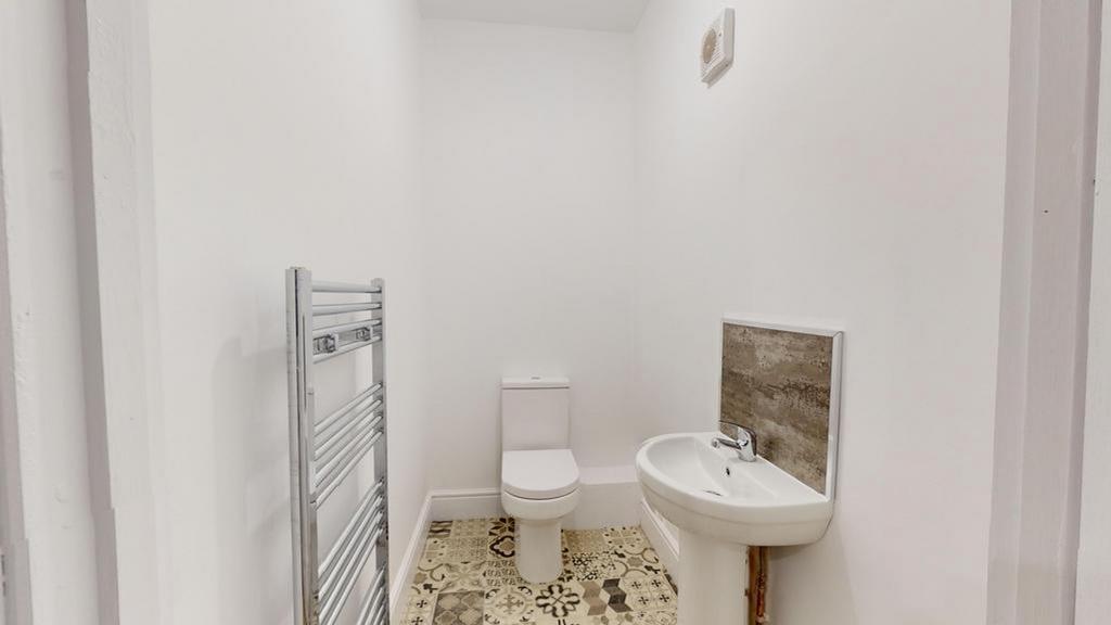 A clean and modern single toilet space with sty...
