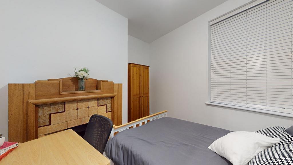 A bright and tidy double bedroom featuring a st...